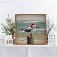 Seagull wearing a Santa hat on a beach with ocean in the background wood sign - Island Soul Clothing & Gifts Seaside Heights New Jersey