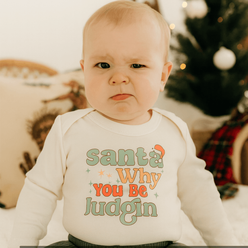 Baby onesie with "Santa Why You Be Judgin'" text on a off white background - Island Soul Clothing & Gifts Seaside Heights