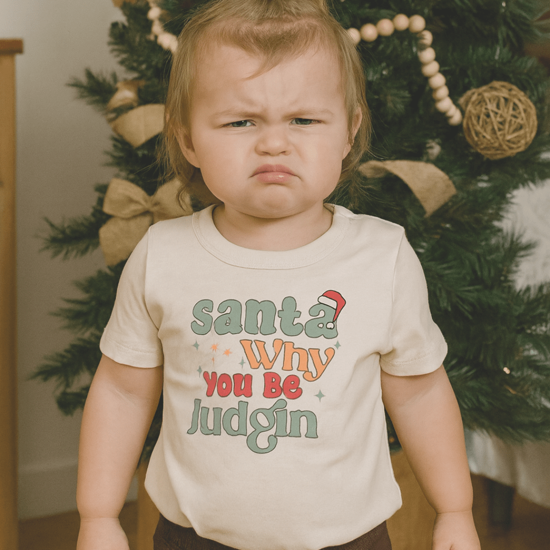 Beige toddler t-shirt with colorful text 'Santa Why You Be Judgin' on a white background - Island Soul Clothing & Gifts Seaside Heights New Jersey